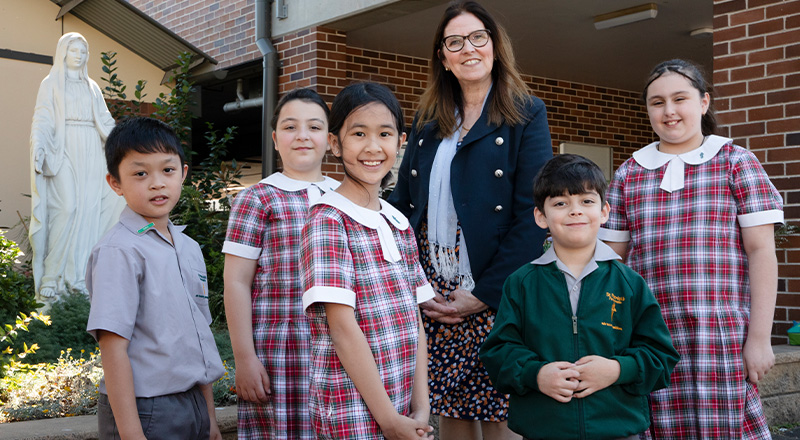 St Patrick's Catholic Primary School Parramatta students standing with school Principal Ms Bernadette Fabri