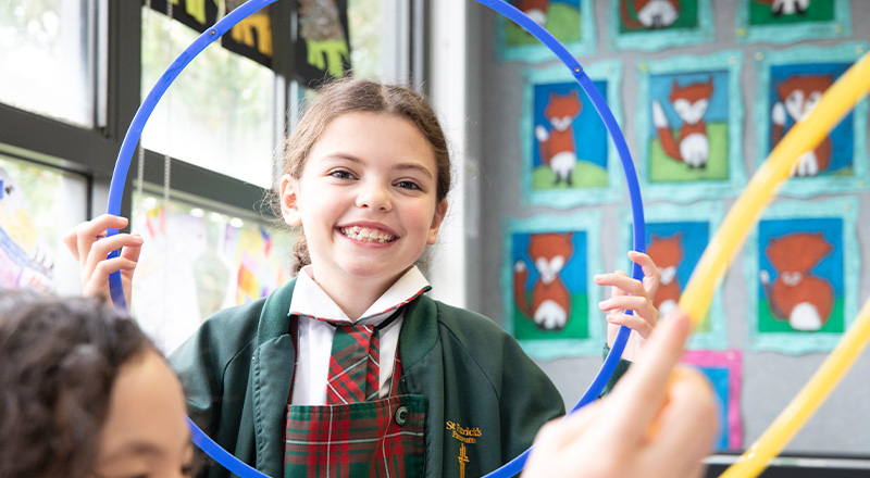 St Patrick's Catholic Primary School Parramatta student laughing through a hoola hoop