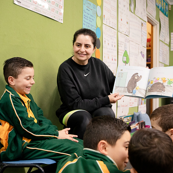 St Patrick's Catholic Primary School Parramatta student sits with enthusiastic parent reading a book